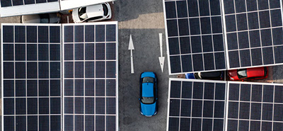 Aerial image of solar panels in a parking lot with cars